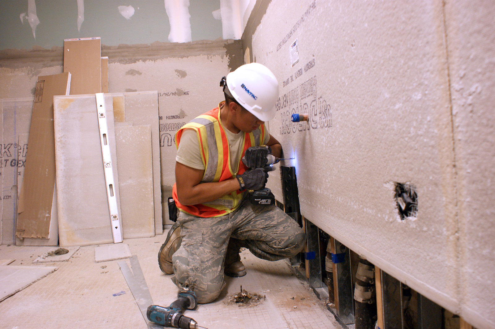 PEARL HARBOR-HICKAM, Hawaii (Jan. 21, 2014)  As part of a complete makeover project, an Air Force apprentice installs Durarock cement backer board to the walls of the men's restroom at the Hickam Gymnasium, Joint Base Pearl Harbor-Hickam.  The renovations began in January 2014 and are expected to continue through February 2014. Photo by Sila Manahane, NAVFAC Hawaii public affairs assistant.