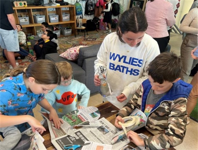 Family members participating in a newspaper fashion activity at the GBB 