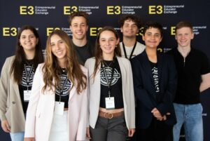 A group of Young People gathered in front of signage at a conference