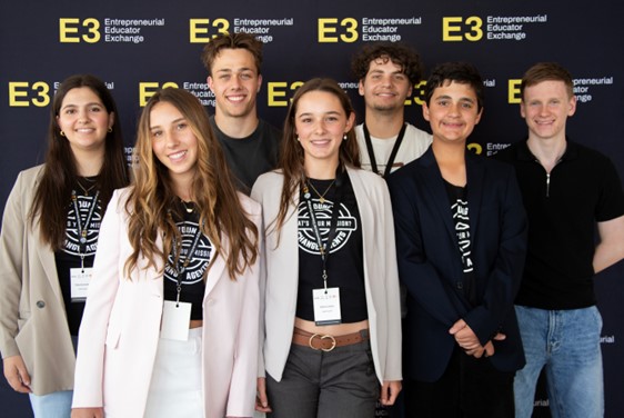 A group of Young People gathered in front of signage at a conference